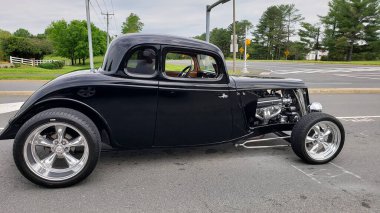 Modifiye edilmiş klasik lowrider hot rod roadster, açık motoru ve büyük lastikleri var.