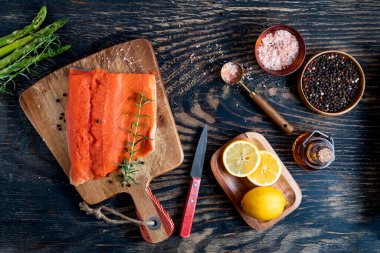 Koyu ahşap arka planda taze çiğ organik somon balığı.