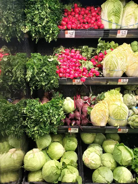 variety of fresh vegetables on the counter of the vegetable department in the store.