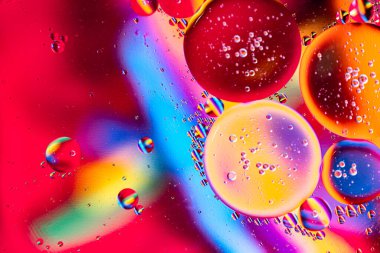 Sıvıdaki yağ kabarcıklarının hareketi. Renkli kabarcıklardan oluşan fantastik bir yapı. Suda yüzen yağ damlasının renkli sanatsal görüntüsü