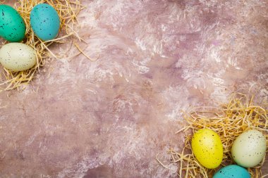 Paskalya yumurtaları samanların üzerinde yatar. Yukarıdan bak. Metin için boşluk