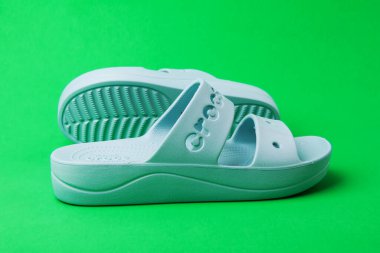 Yeşil arka planda rahat timsah sandaletleri. Lastik sandaletler, moda plaj ayakkabıları..