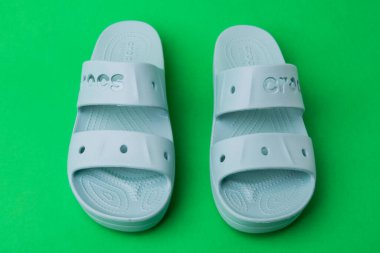 Yeşil arka planda rahat timsah sandaletleri. Lastik sandaletler, moda plaj ayakkabıları..