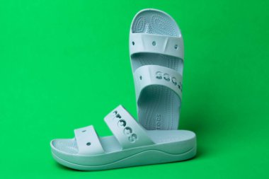 Yeşil arka planda rahat timsah sandaletleri. Lastik sandaletler, moda plaj ayakkabıları..