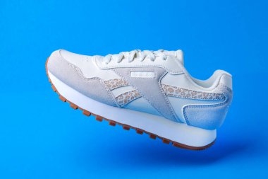 Mavi arka planda Reebok Ortolit beyaz deri spor ayakkabısı.