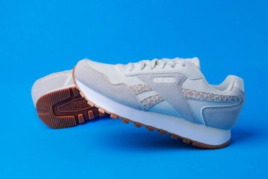 Mavi arka planda Reebok Ortolit beyaz deri spor ayakkabısı.