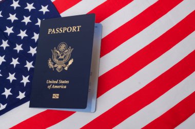 Amerikan vatandaşının pasaportu Amerikan bayrağının arka planında.