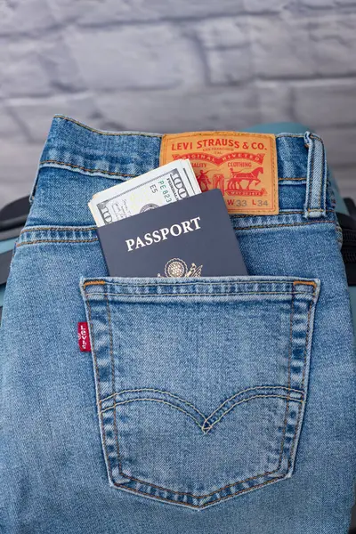 レヴィのジーンズ アメリカのパスポート ポケットの中のドルはアメリカのシンボルです トラベルコンセプト ストック画像