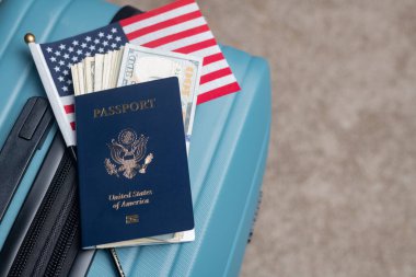 Amerikan vatandaşı pasaportu, Amerikan bayrağı ve doları seyahat bagajında yatıyor.