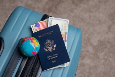 Dünya, Amerikan pasaportu, Amerikan bayrağı ve doları seyahat bagajında yatıyor.