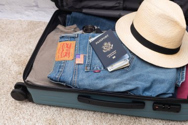 Levi 'nin kotu, bir Amerikan pasaportu, dolar ve diğer şeyler bir bavulun içinde. Seyahat kavramı.