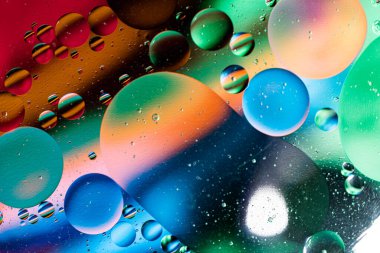 Sudaki yağ kabarcıklarının renkli soyutlanması. Yukarıdan bak. Makro fotoğrafçılık.