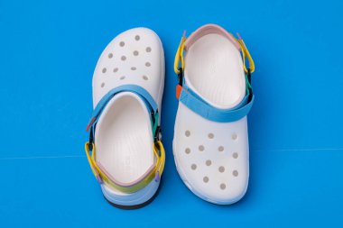 Timsahlar rahat sandaletler ve mavi arka planda kayışlar..