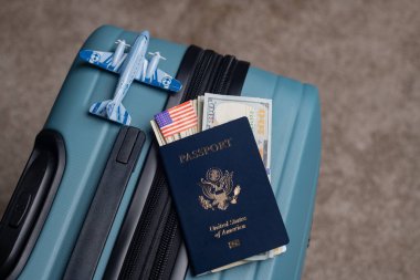 Bir Amerikan vatandaşı pasaportu ve Amerikan doları seyahat bagajında bir model uçağın yanında yatar..