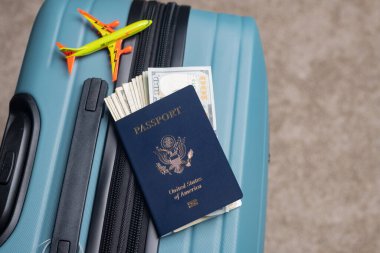 Bir Amerikan vatandaşı pasaportu ve Amerikan doları seyahat bagajında bir model uçağın yanında yatar..