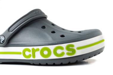 Beyaz arka planda belirgin bir tasarımı olan gri timsah sandaletleri.