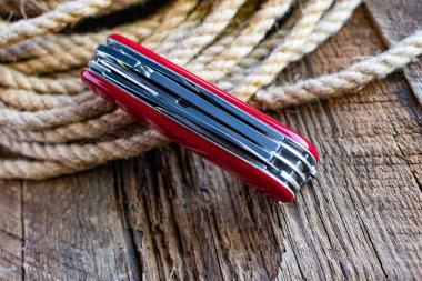 Çoklu işlevsel ordu bıçağını halatın arka planına yakın çekim. Güvenilir bir araç. İsviçre hassasiyeti.