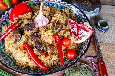 Etli pilav ve kurutulmuş meyveler servis tabağında servis edilir..