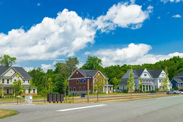 stock image new two story houses along the road under a blue sky with clouds, New Neighborhood in Leesburg, Virginia.