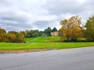 Büyük tuğla çiftçisinin evi. Mavi gökyüzünün altında büyük bir tarla.