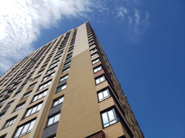 Mavi gökyüzüne karşı çok katlı bir apartman. Konut alanlarında tipik gelişmeler.