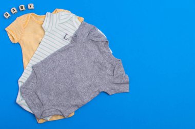 Bebek için farklı renkte tişörtler. Yukarıdan bak. Metin için boşluk.