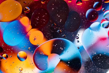 Petrol baloncuklarının hareketi. Renkli kabarcıklardan oluşan fantastik bir yapı. Soyut renkli arkaplan. Suda yakın çekim kabarcıkları.