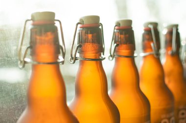 Borazanlı kahverengi bira şişeleri pencerenin yanında duruyor.