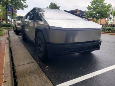 Tesla electric Cybertruck in a store parking lot with raindrops on the hood. Front view. clipart