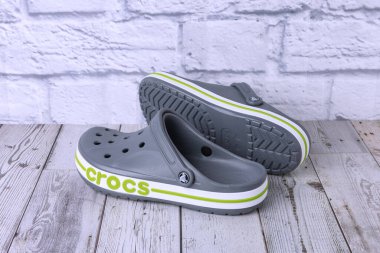 Yeşil CROCS yazıtlı gri sandaletler. Gri zeminde rahat unisex plaj ayakkabıları.