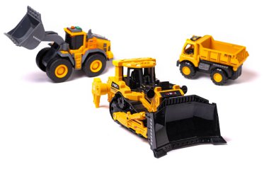 Ağır inşaat malzemeleri. Sarı buldozer, beyaz arka planda çöp kamyonu ve yükleyici. Oyuncak kopya.