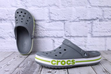 Yeşil CROCS yazıtlı gri sandaletler. Gri zeminde rahat unisex plaj ayakkabıları.