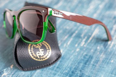 Yeşil çerçeveli ve mavi masalı Ray-Ban güneş gözlüğü. Popüler ve modaya uygun aksesuarlar.