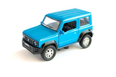 Suzuki Jimny off-road aracı, mavi. Turizm ve aşırı maceralar için bir araba. Beyaz arkaplanda oyuncak modeli.