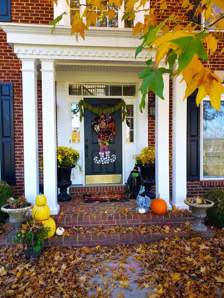 stock image front porch with steps is decorated for Halloween, featuring pumpkins, cobwebs, ghosts, and spooky lights, creating a festive and eerie atmosphere.