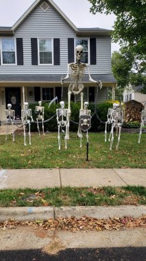 Cadılar Bayramı süslemeleri evin önündeki çimenlikte. İskeletler ve hayaletler korku ve korku ortamı yaratır..