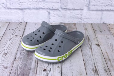 Yeşil CROCS yazıtlı gri sandaletler. Gri zeminde rahat unisex plaj ayakkabıları.