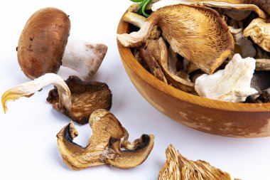 Tahta bir kasede farklı mantarların kuru dilimleri gurme gıda malzemesi olarak sebze organik protein eğilimi.