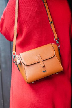 Labbra çantası kırmızı hırkalı bir kadının omzunda asılı. Yakın plan..