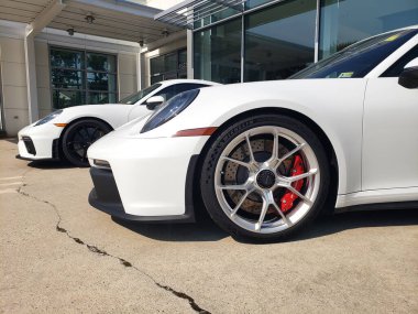 Beyaz Porsche 911, araba galerisinin otoparkında..