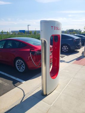 Tesla elektrikli arabası, yüksek hızlı akü şarjı için bir rıhtım istasyonuna park edilmiş.
