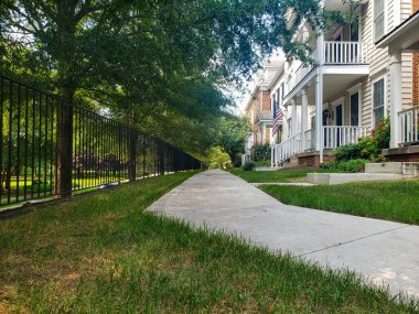 Ayrılmış tek aile evleri boyunca beton kaldırımlar.