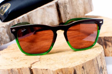 Ray-Ban güneş gözlüğü ve üzerinde Rayban marka logosu olan deri çanta..