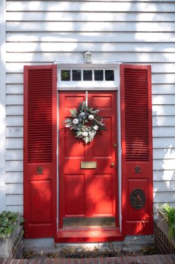 Kırmızı ahşap dış kapı, tuğla pervazlı..