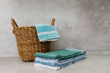 Hasır sepet ve bir yığın temiz mutfak renkli havlu. Boşluğu kopyala.