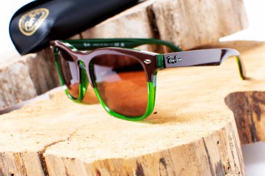 Ray-Ban güneş gözlüğü ve üzerinde Rayban marka logosu olan deri çanta..