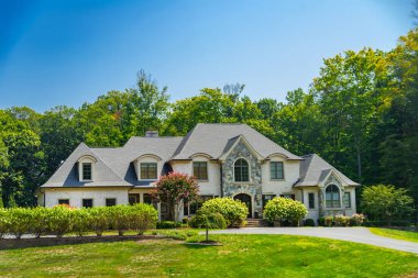 Geniş, modern kır evi manzarası. Peyzaj tasarımı, biçilmiş çimler ve mavi gökyüzü.