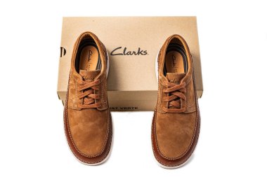 Cardboard box and suede demi-seasonal boots from the brand Clarks on a white background. clipart