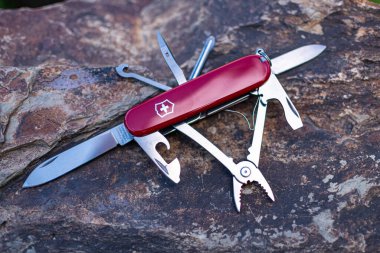 Victorinox Spartan İsviçre çakısını taştan arka planda katlıyor
