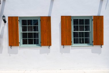 Eski bir taş evin duvarında panjurları olan iki antika pencere..